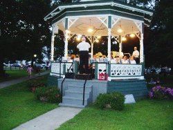 Close-up of Gazebo with conductor and musicians within- photo taken from behind conductor who is facing the musicians